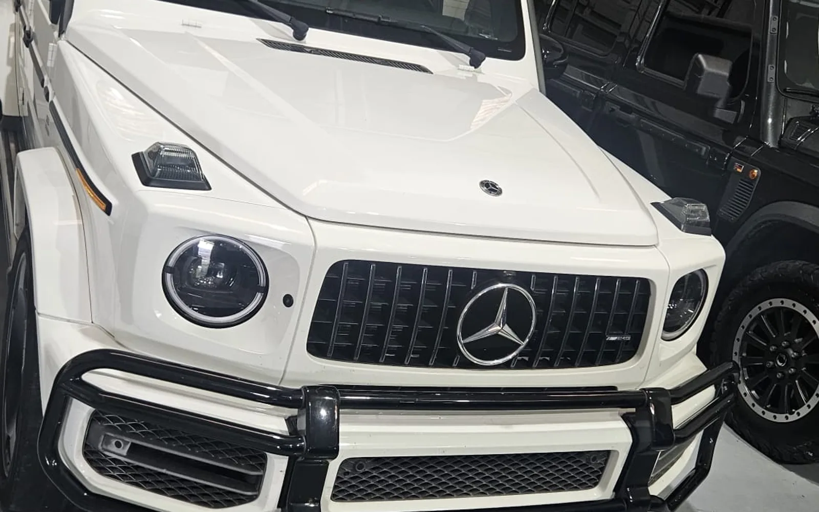 White Mercedes-Benz G 63 AMG with red interior and bull bar